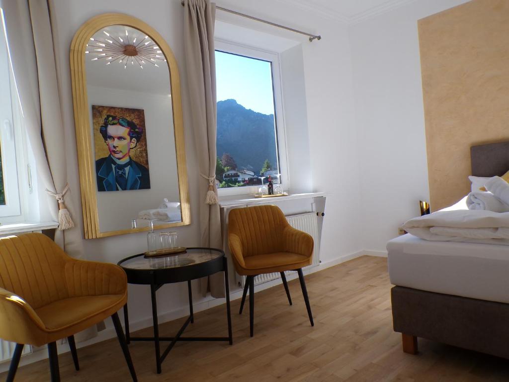 a bedroom with a bed and a mirror and a table at Pension und Ferienwohnung Frech in Marktschellenberg