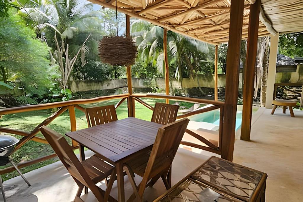 a wooden table and chairs on a porch at CASA 2 HAB Alberca y Parking privado in Bacalar