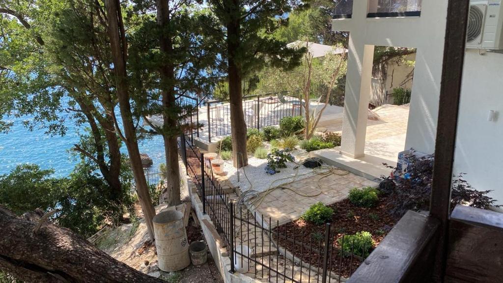 a cross on the side of a building next to the ocean at Apartment Botanicheskiy Sad in Sutomore