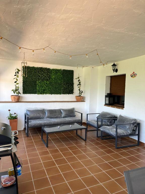 a living room with couches and a green wall at El Refugio in Fondón