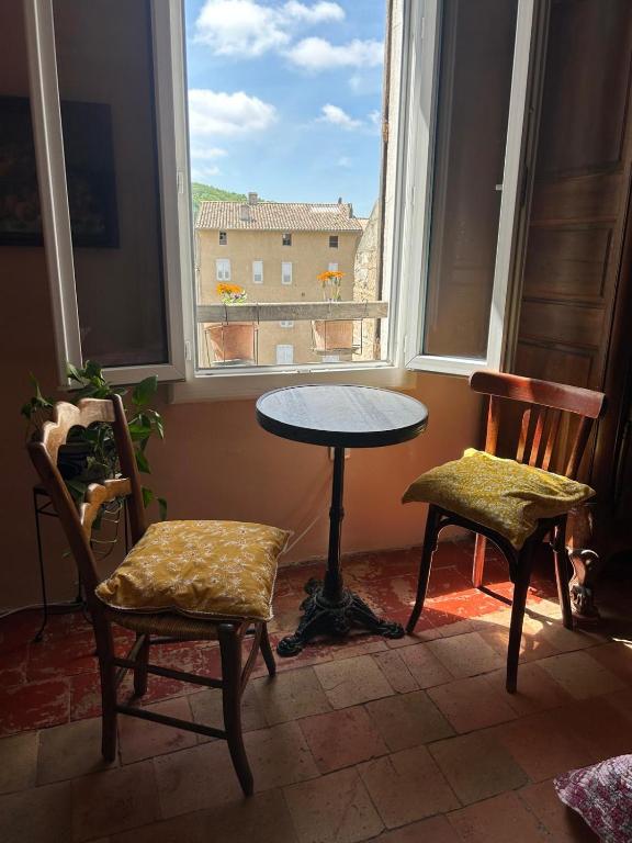 a table and two chairs in a room with a window at Chambre in Riez