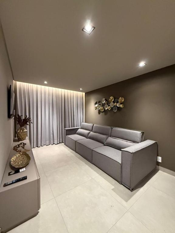 a living room with a couch and a table at Apartamento Boutique Cheia de Graça 304 in Divinópolis
