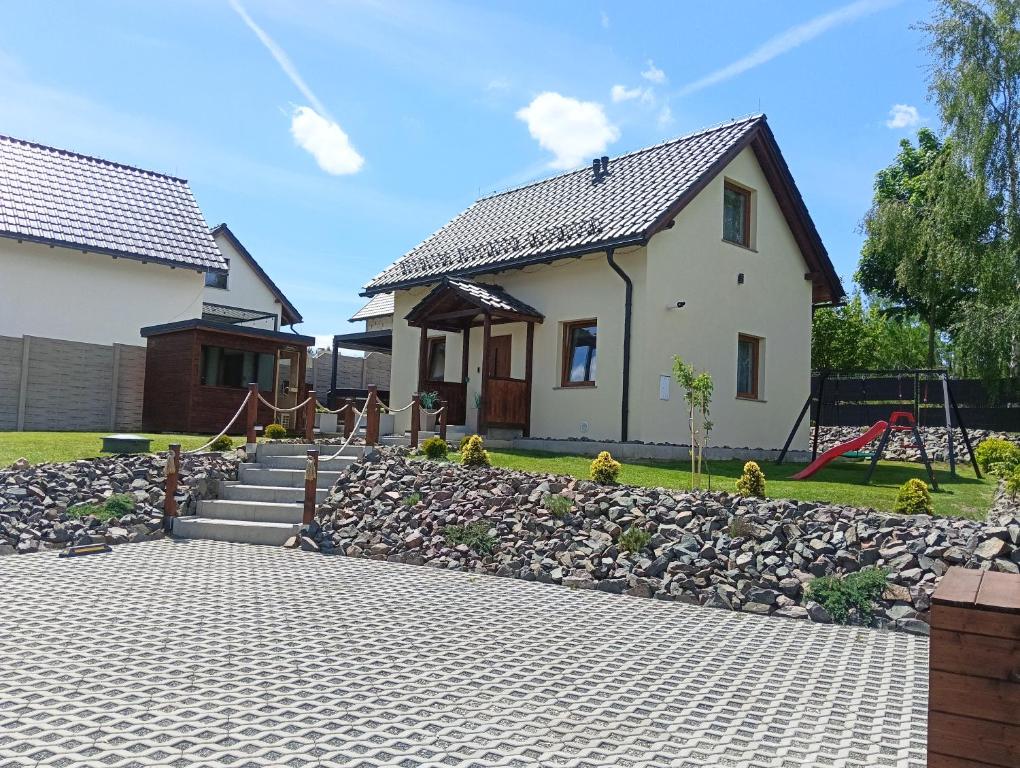 a house with a stone path in front of a house at Letnisko domek z Sauną i Balią in Lubawka