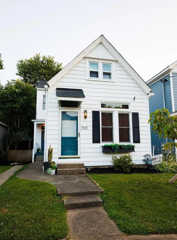 a white house with a blue door at Barrel House on Derby Row in Louisville