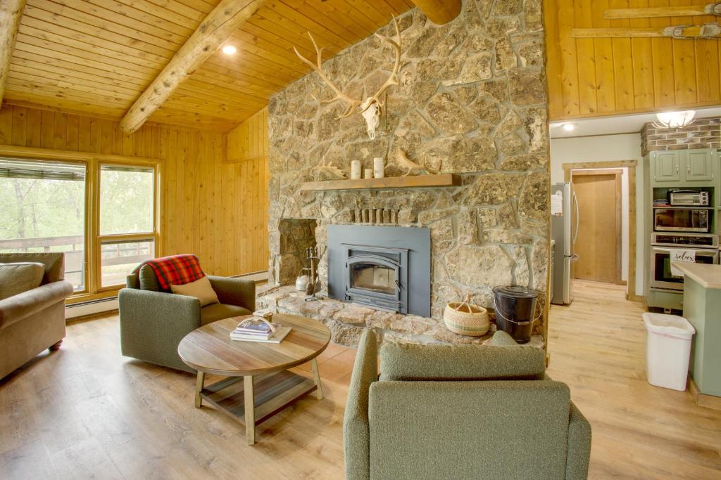 a large living room with a stone fireplace at Mountain Views + BBQs: Updated Cody Cabin in Cody