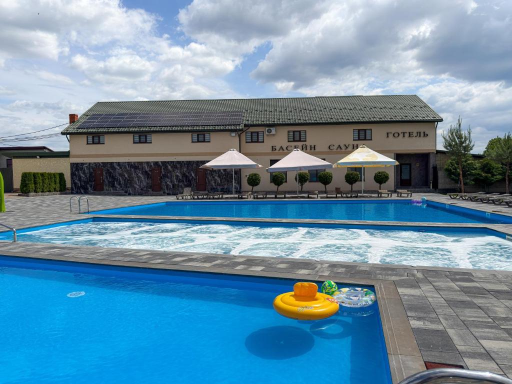a swimming pool with a toy in front of a hotel at Hotel ELYSIUM in Irshava