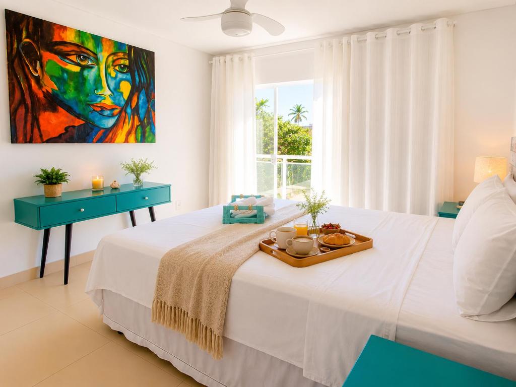 a bedroom with a bed with a tray of food on it at casa amplia y luminosa en porto da barra in Búzios