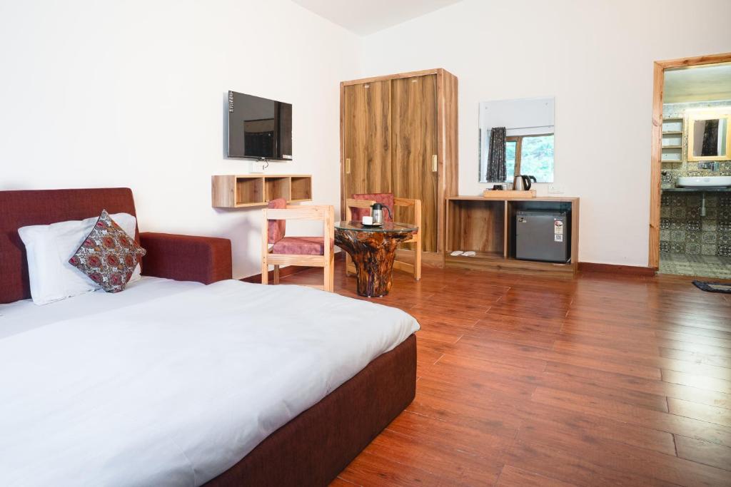 a bedroom with a bed and a table and a kitchen at Wildernest Resort in Kota Bāgh