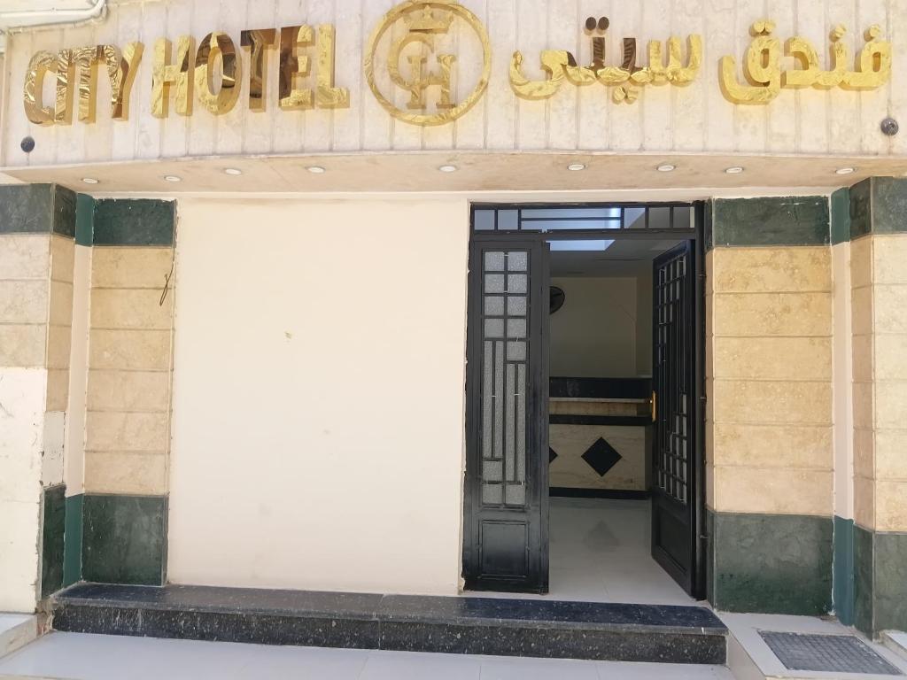 an open door to a building with a sign at City Hotel in Luxor