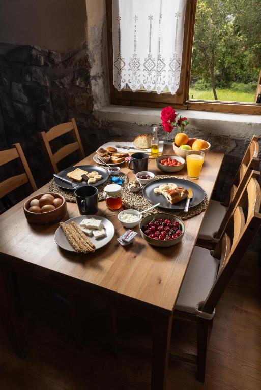 a wooden table with breakfast food on it at PETRASTERO Mountain Retreat-Agrafa Evrytania Greece in Vérnikon