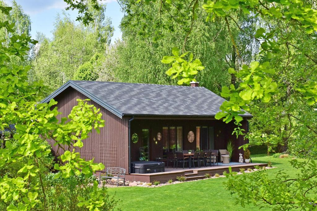 a small shed with a porch in a garden at Pramogų namelis in Naručionys