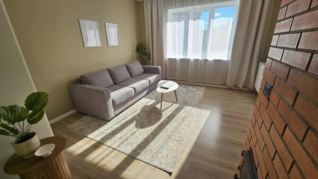 a living room with a couch and a table at Ülejõe Apartment with Free Parking in Pärnu