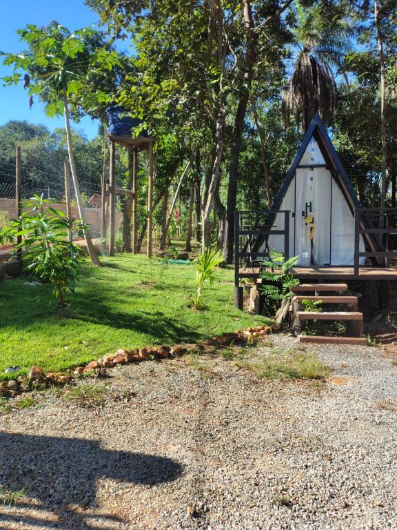 a small cabin in a field with trees at Cantinho do Chalé in Jaboticatubas