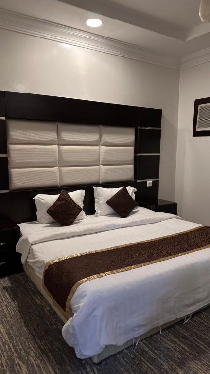 a bedroom with a large bed with a large headboard at شقق ركن التاسيس in Najran