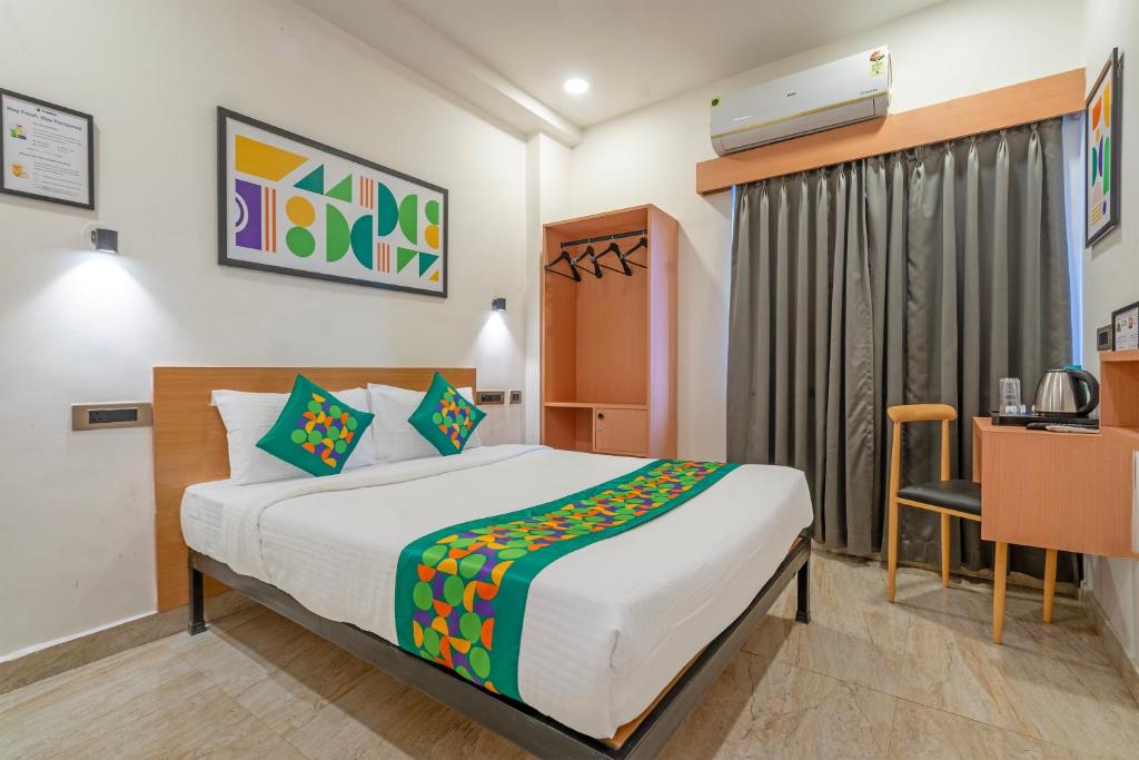 a bedroom with a bed and a desk in a room at Treebo The Trio, Karmanghat in Hyderabad