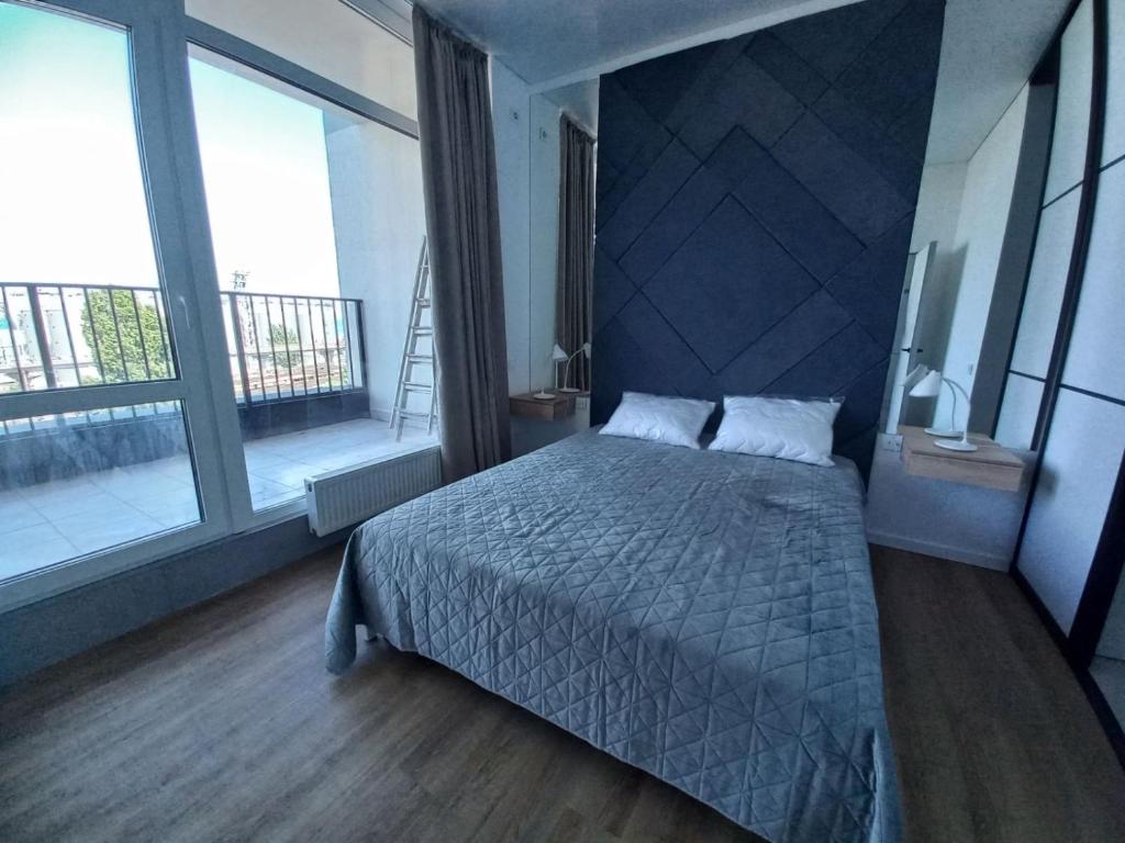 a bedroom with a bed and a large window at Itown Apartments in Odesa