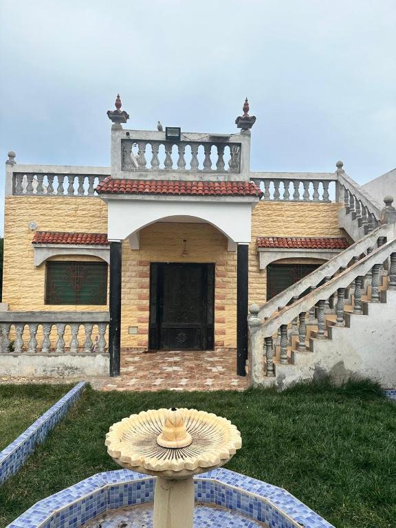 a house with a staircase and a fountain in front of it at Villa Bingo & Piscine in El Jadida