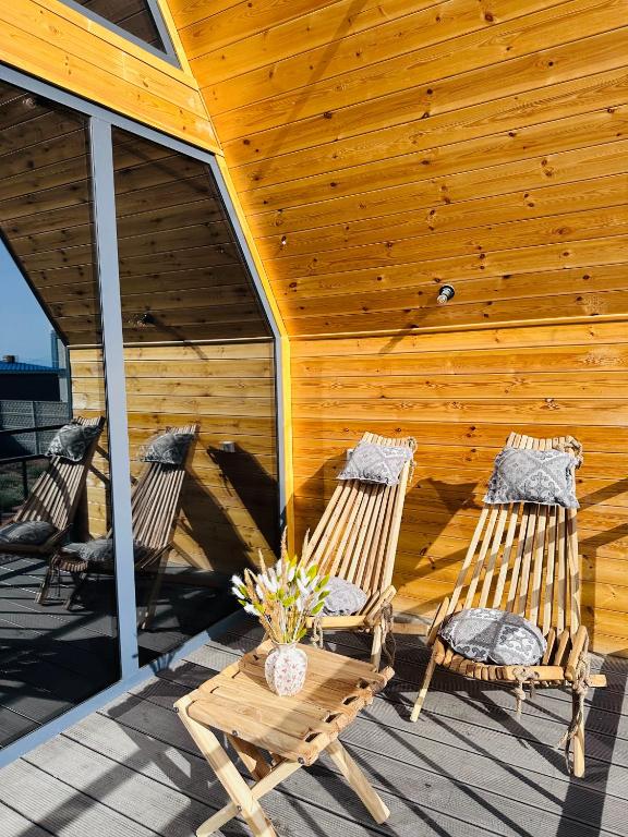 two chairs and a table in front of a building at Tengri House A-Frame Issyk-Kul in Kaji-Say