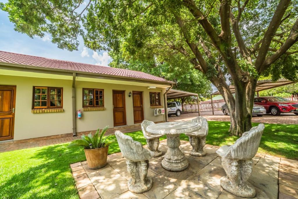 a table and chairs in front of a house at Beryl1 Guest House in Klerksdorp