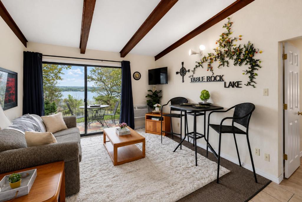 a living room with a couch and a table at Poolside Retreat at Kimberling Crossing in Kimberling City