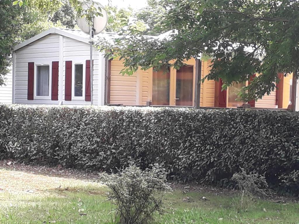 a house behind a hedge in front of a house at danseuse 33 in Parentis-en-Born