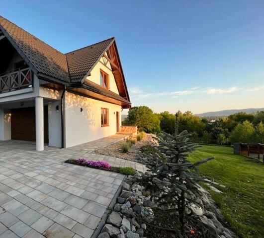 a house with a stone walkway in front of a yard at Zacisze Wilcza in Zarzecze