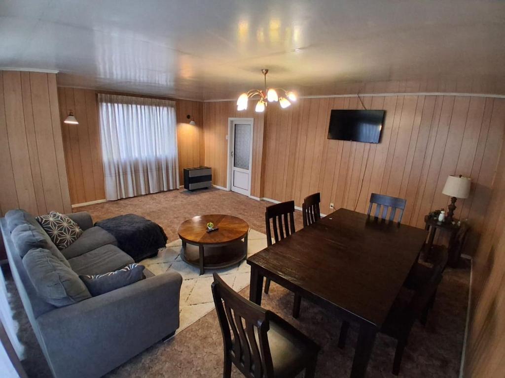 a living room with a couch and a dining room table at La Casona - Refugio Austral in Punta Arenas