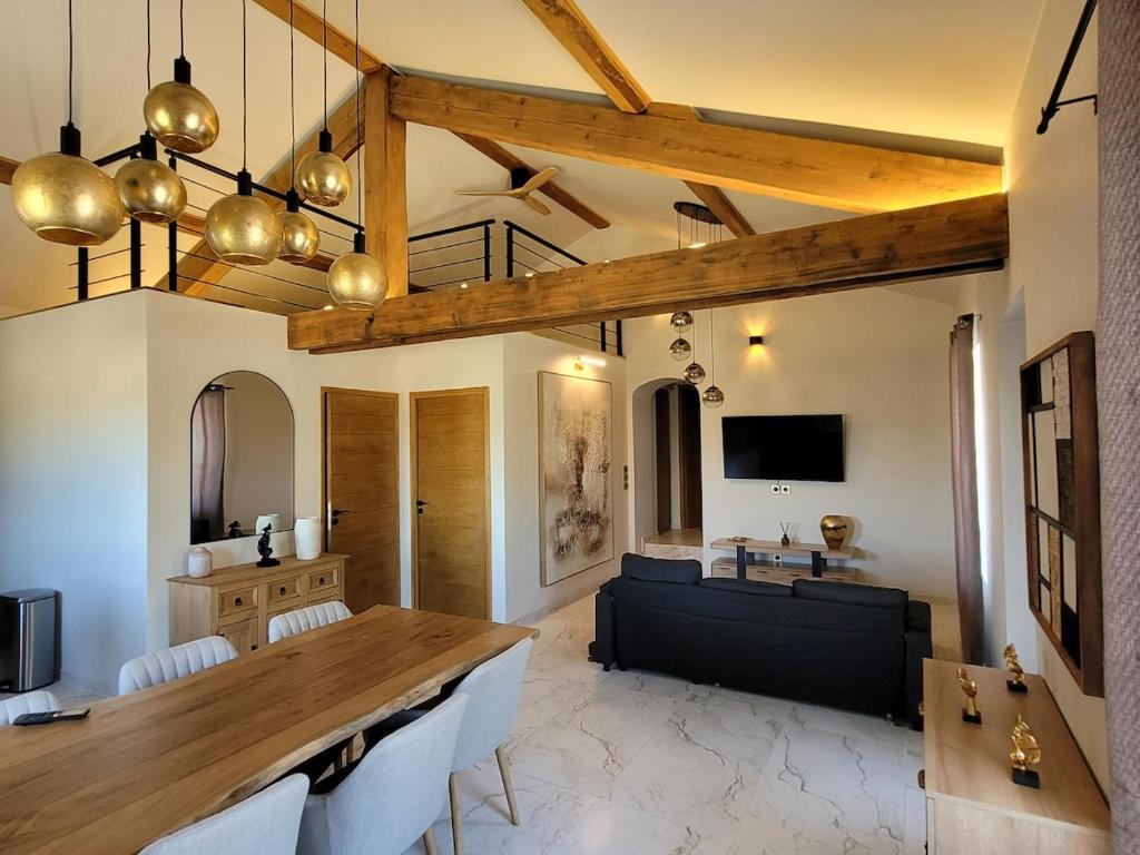 a living room with a table and a couch at L'Écrin de Nature Panoramic View & Prestige in Saint-Marcel-lès-Annonay