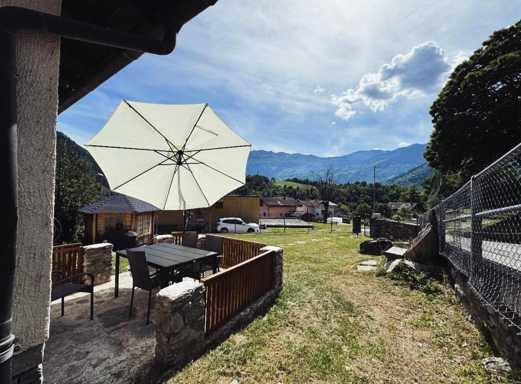 a patio with a table and an umbrella at Casa del Sole in Dangio