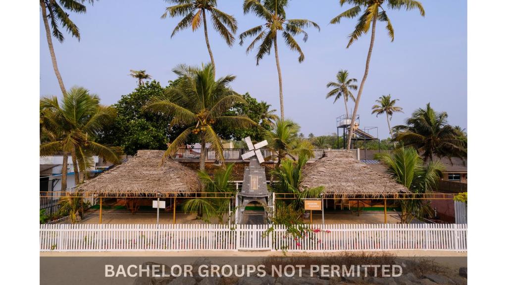 a resort with palm trees and a sign that reads backpacker groups not permitted at Jonirene Seasands Homestay in Alleppey