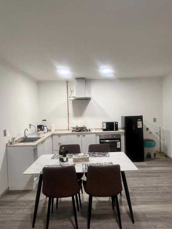 a kitchen with a table and chairs in a room at Refugio Austral in Punta Arenas