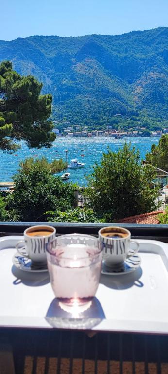 a table with two cups and a bowl on top of it at Tetka Apartments in Kotor