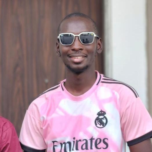a man wearing sunglasses and a pink shirt at Aromat villa in Kano