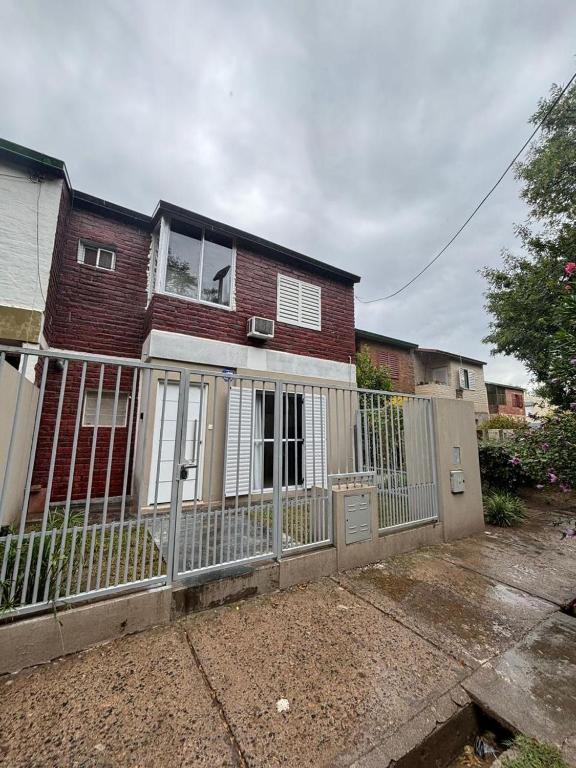 a house with a fence in front of it at Duplex Los Molles in Santa Rosa