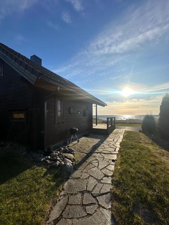 ein Haus mit einem Steinweg neben einem Gebäude in der Unterkunft Seaside Cabin in Aabla
