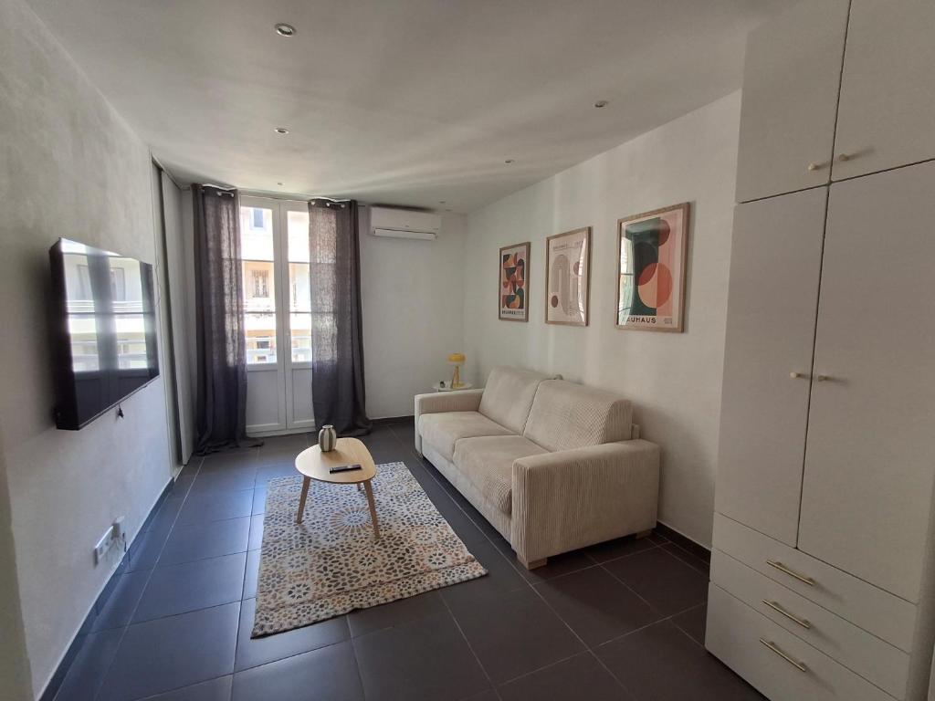 a living room with a couch and a table at Joli T1 bis - Centre ville in Bastia