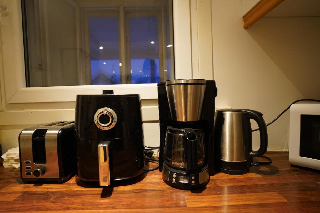 three coffeemakers sitting on top of a table at Comfort Apartment in Tromsø