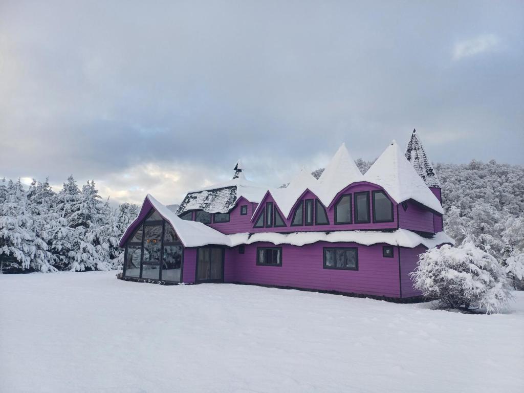 a purple house with snow on top of it at Spectra Lodge Boutique Hotel in Malalcahuello