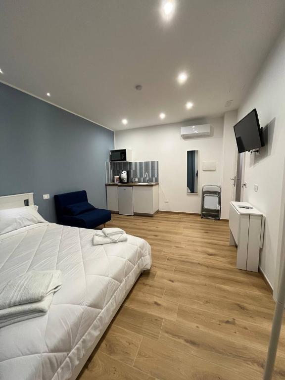 a bedroom with a white bed and a blue chair at The Family Rooms, Rione alto, Zona ospedaliera in Naples