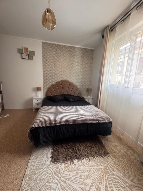 a bedroom with a large bed and a window at Studio centre ville in Évreux