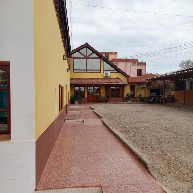 ein Gebäude mit einem Backsteinpflasterweg vor einem Gebäude in der Unterkunft Hotel Arauco in Aimogasta