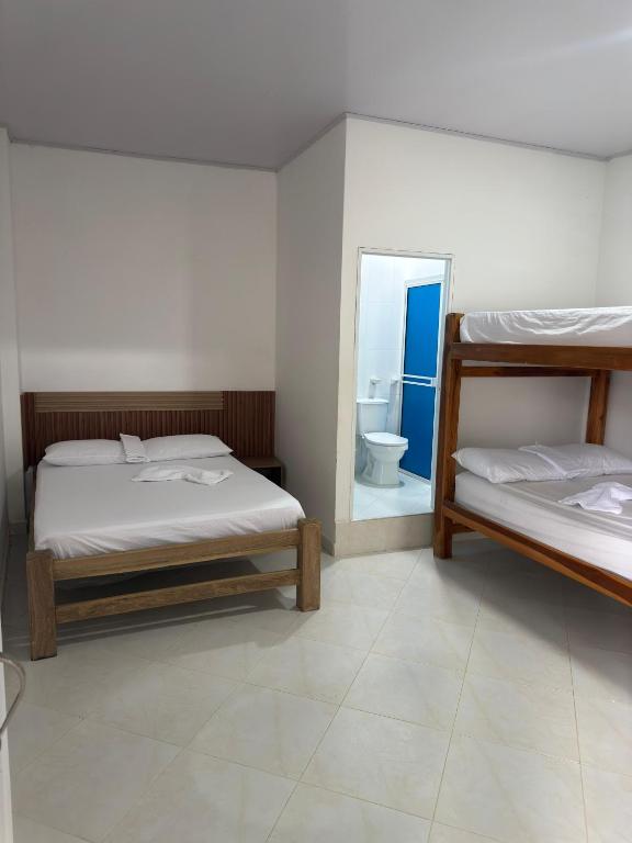 a bedroom with two bunk beds and a mirror at WARI RUNA HOSTAl 101 in Necoclí