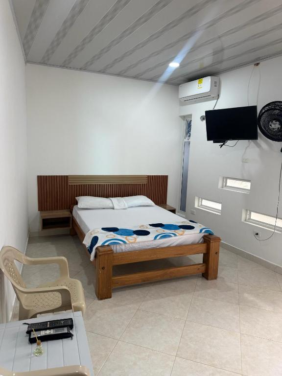 a bedroom with a bed and a tv and a table at WARI RUNA HOSTAl 103 in Necoclí