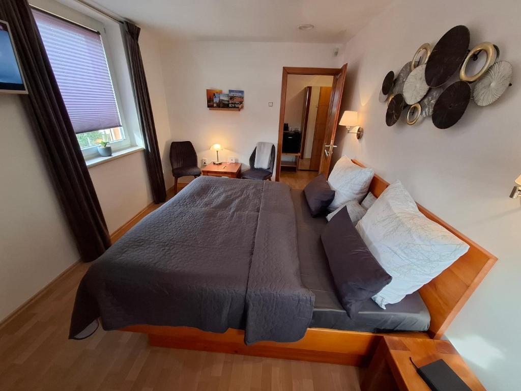 a bedroom with a large bed and a window at Susann Vendégház in Szigetmonostor