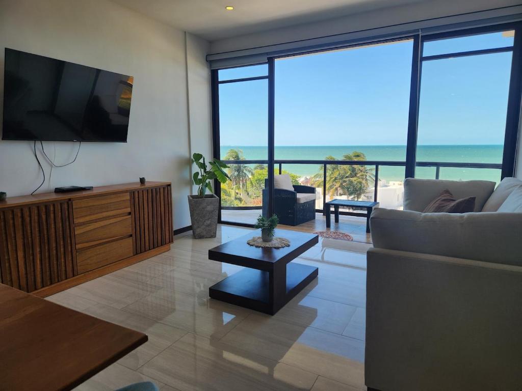 a living room with a tv and a couch and a table at Apartment in Chixchulub with a spectacular view in Chicxulub