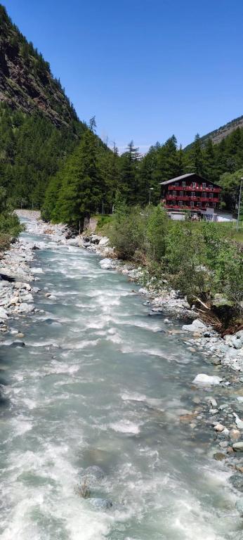 a river with snow on the side of a mountain at Pension Waldegg Zermeiggern in Saas-Almagell