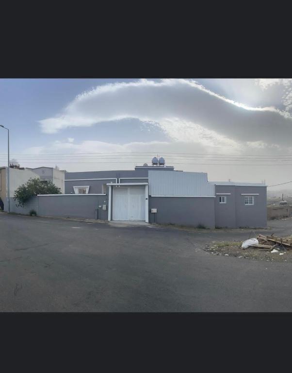 a large white building with a garage and a sky at دور سياحي in Abha