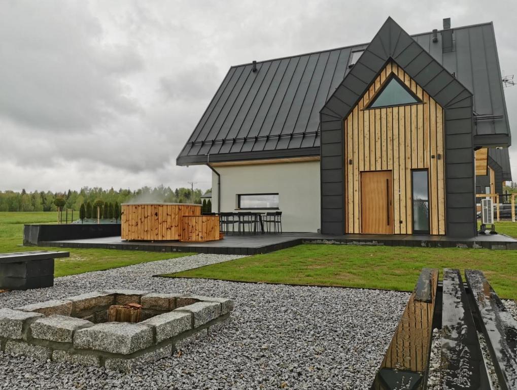 a house with a black roof and a fire pit at Kącik Na Dolinie in Groń