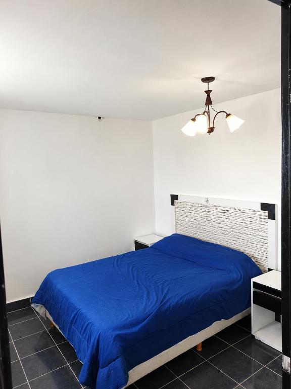 a bedroom with a blue bed and a ceiling at El Rincón de km8 in Comodoro Rivadavia