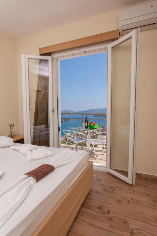 sypialnia z łóżkiem i balkonem z widokiem na ocean w obiekcie Villas Odysseas w mieście Nydri